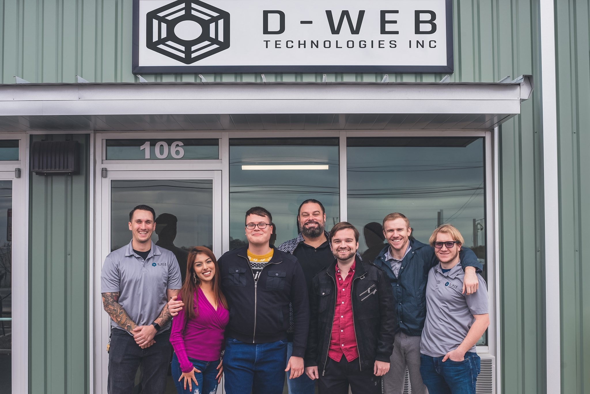 D-Web Technologies Inc. team standing in front of the office